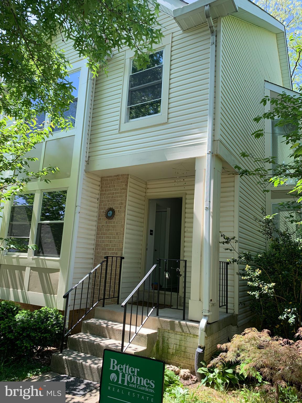 a view of small house with yard and sitting area