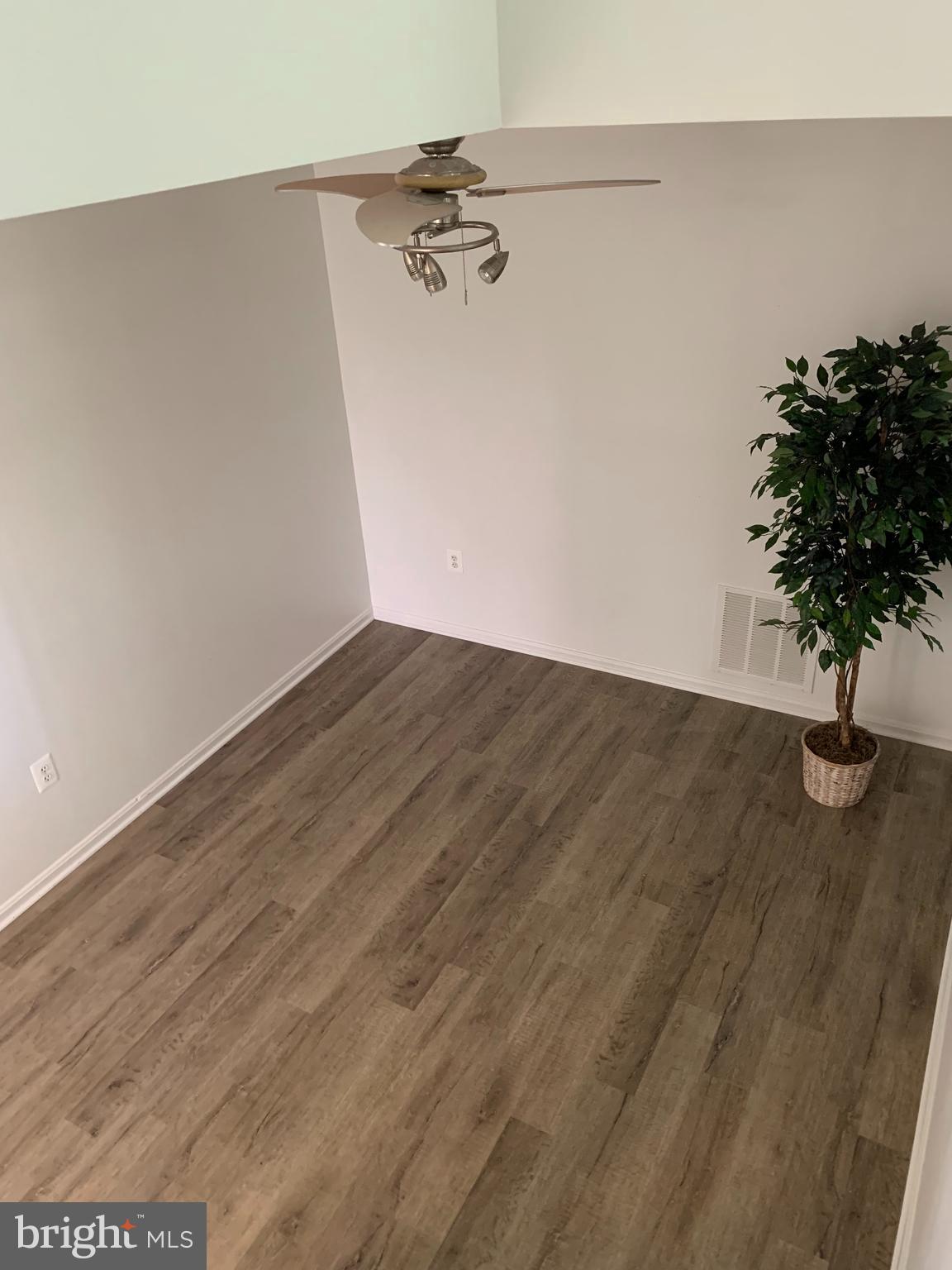 5478 Stavendish Street Burke, VA 22015 - Photo 17 of 24 a view of a room with wooden floor and a potted plant