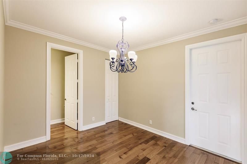 116 Southeast Crestwood Circle Stuart, FL 34997 - Photo 11 of 48 an empty room with chandelier fan and wooden floor