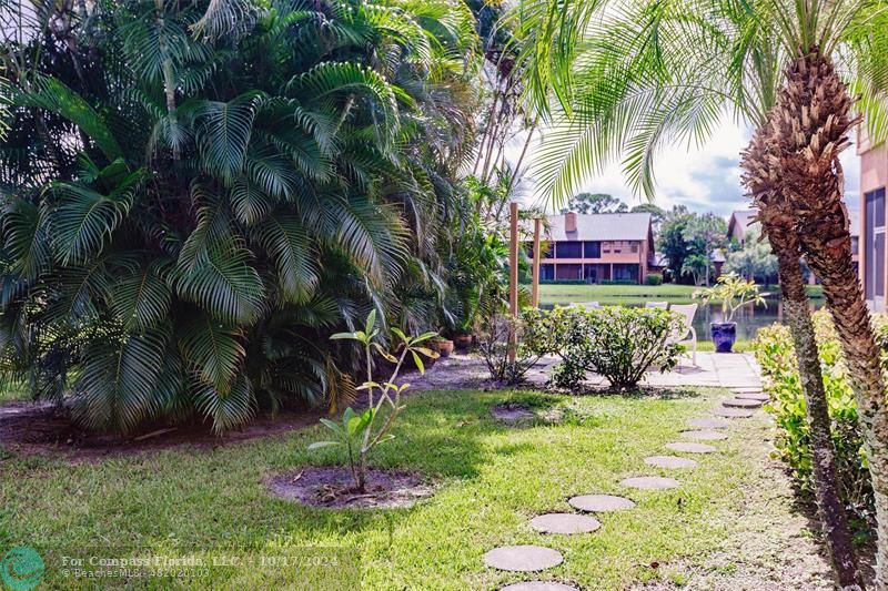116 Southeast Crestwood Circle Stuart, FL 34997 - Photo 20 of 48 a couple of flower plants in front of a house
