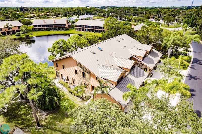 116 Southeast Crestwood Circle Stuart, FL 34997 - Photo 2 of 48 an aerial view of a house with a garden and lake view