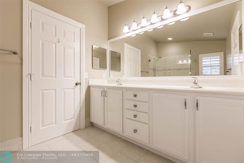 116 Southeast Crestwood Circle Stuart, FL 34997 - Photo 36 of 48 a bathroom with a double vanity sink a mirror a vanity and