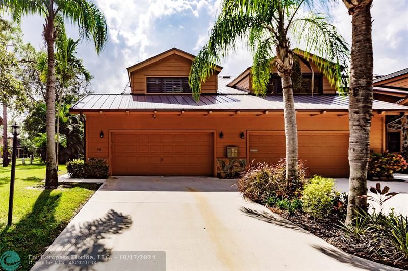 116 Southeast Crestwood Circle Stuart, FL 34997 - Photo 46 of 48 a front view of a house with a garden