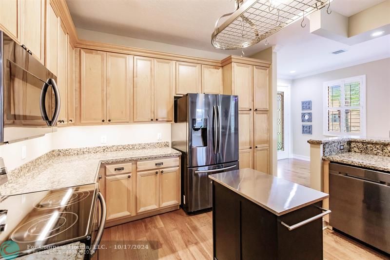 116 Southeast Crestwood Circle Stuart, FL 34997 - Photo 6 of 48 a kitchen with stainless steel appliances granite countertop a refrigerator a stove and a sink with large window