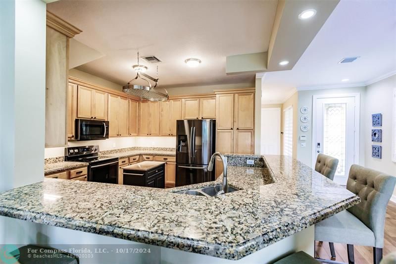 116 Southeast Crestwood Circle Stuart, FL 34997 - Photo 7 of 48 a kitchen with stainless steel appliances granite countertop a sink stove and refrigerator