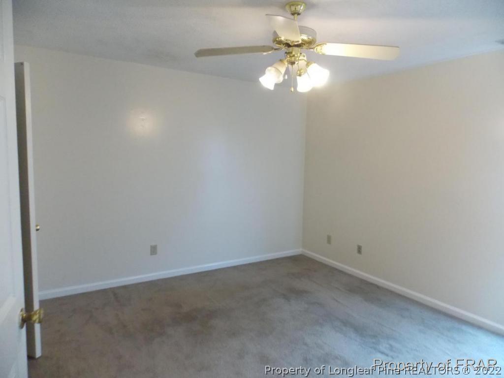 10071 Rockfish Road Raeford, NC 28376 - Photo 8 of 15 an empty room with a window and a chandelier fan