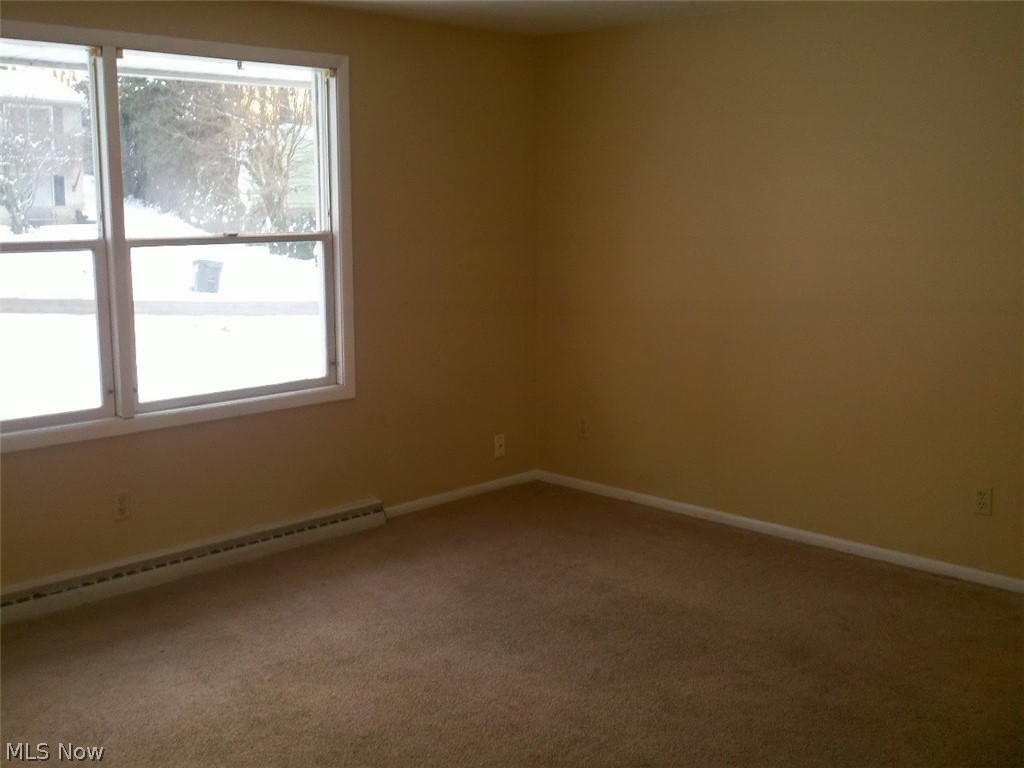 4619 15th Street Northwest Canton, OH 44708 - Photo 11 of 26 Spare room featuring a healthy amount of sunlight, baseboard heating, and carpet