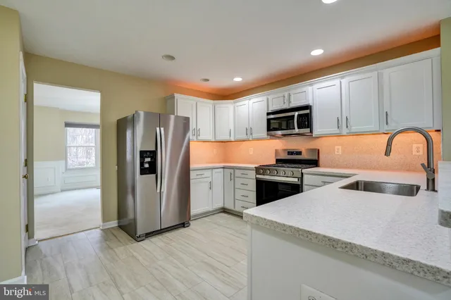 a kitchen with stainless steel appliances granite countertop a refrigerator stove and sink