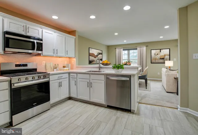 a kitchen with stainless steel appliances a stove sink microwave and cabinets