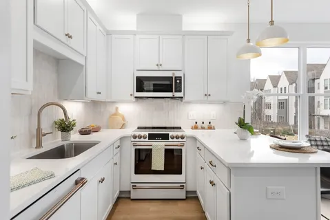 a kitchen with white cabinets and white appliances