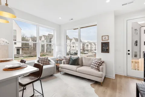a living room with furniture and a floor to ceiling window