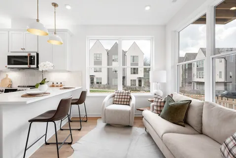 a living room with furniture a flat screen tv and a large window