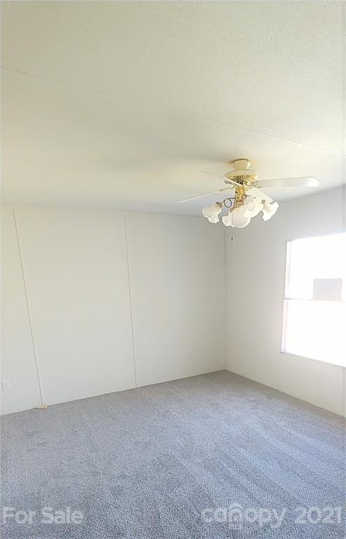 4335 Willis Hollis Road Edgemoor, SC 29712 - Photo 10 of 26 an empty room with windows and chandelier fan