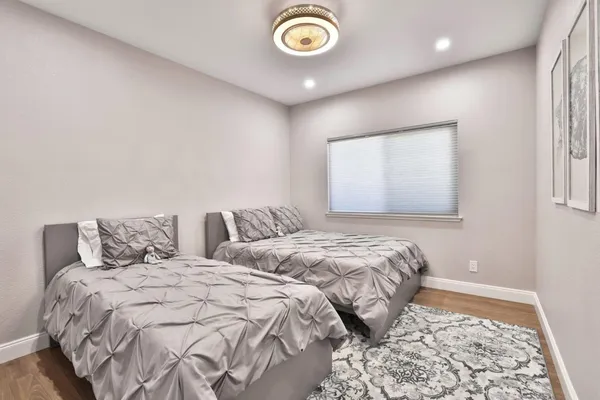 a bedroom with two beds and a lamp