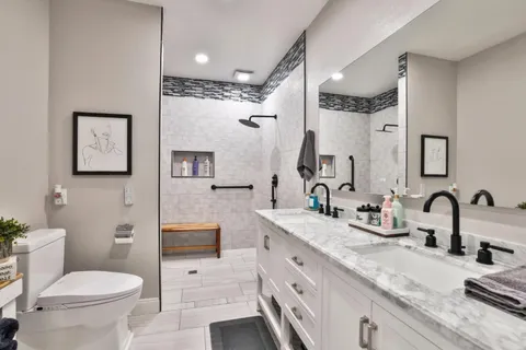 a bathroom with a granite countertop sink mirror and toilet