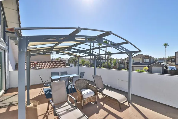 a roof deck with table and chairs