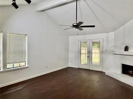 an empty room with windows and fireplace