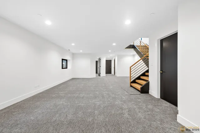 a view of an empty room with stairs and way to room