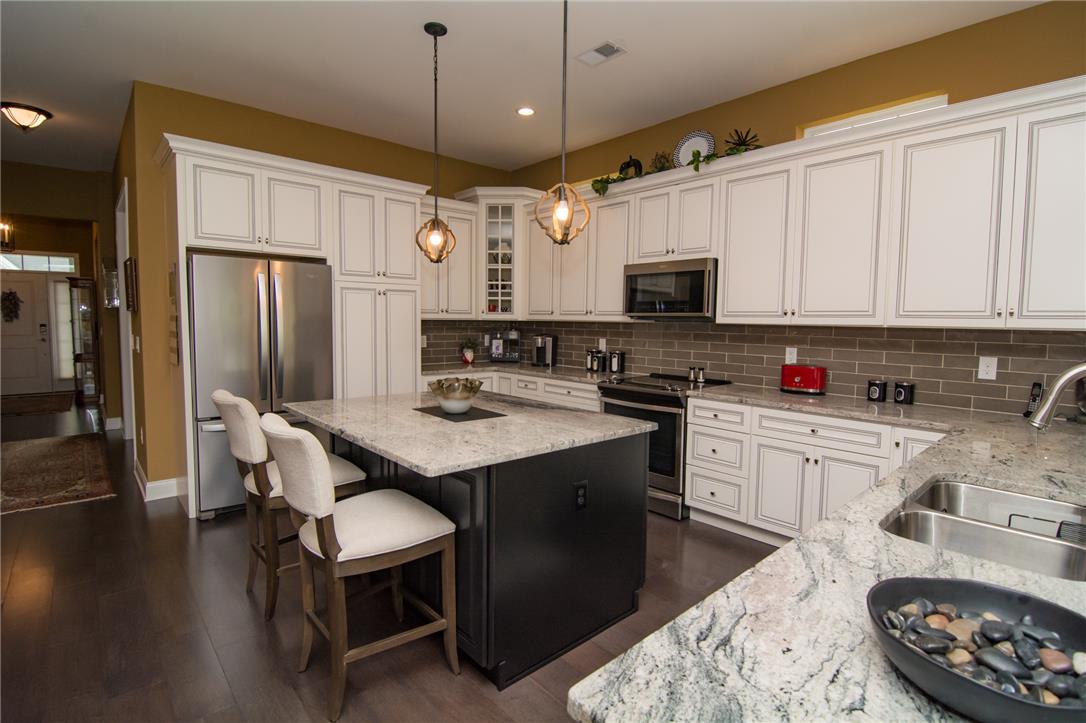 4097 Rutz Lane Allentown, PA 18104 - Photo 6 of 59 Gleaming granite countertops pair beautifully with white cabinetry and a central dark kitchen island.