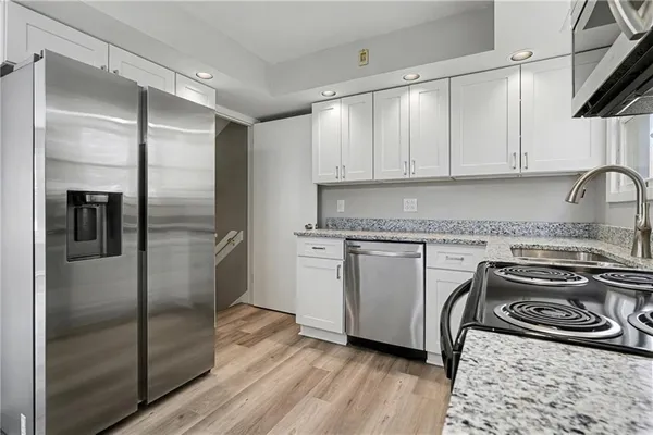 a kitchen with a refrigerator sink and cabinets