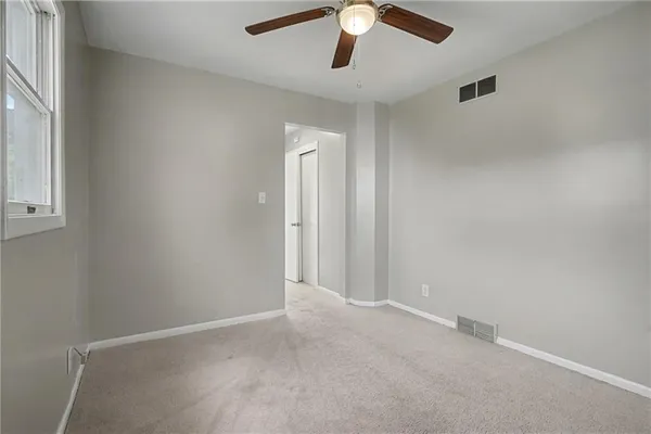 an empty room with a empty space and a ceiling fan