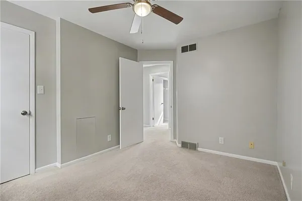 an empty room with a ceiling fan and a window