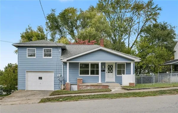 a front view of a house with a garden and yard
