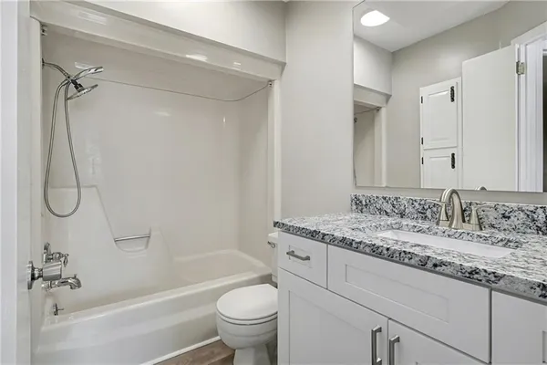 a bathroom with a granite countertop sink toilet and shower