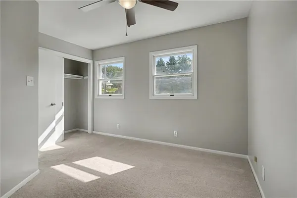 an empty room with windows and closet