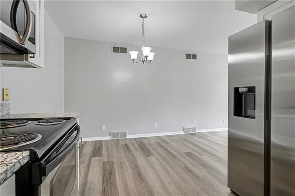 a view of a kitchen with a stove wooden floor and a ceiling fan