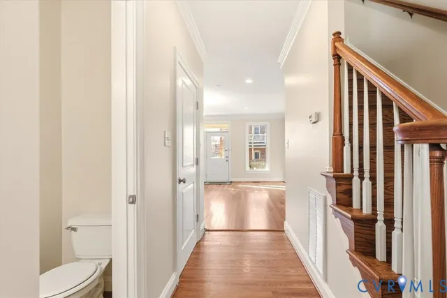 a view of a hallway with wooden floor and staircase