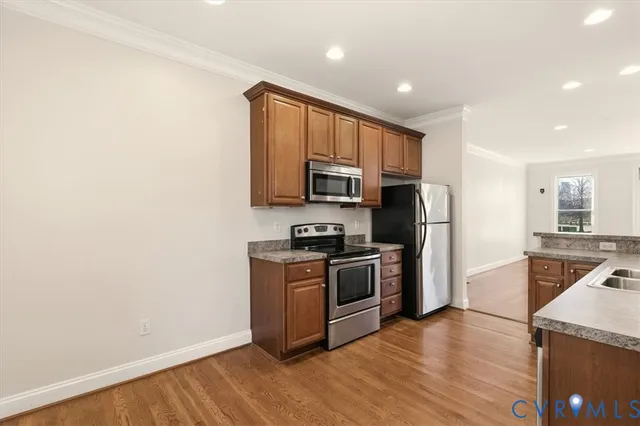 a kitchen with granite countertop a refrigerator stove and microwave