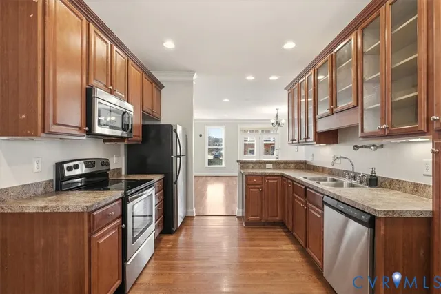 a kitchen with stainless steel appliances granite countertop a stove a sink dishwasher a refrigerator and cabinets with wooden floor