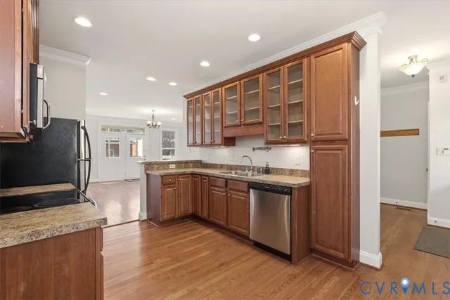 a kitchen with stainless steel appliances granite countertop a refrigerator a sink dishwasher a stove with wooden cabinets and floor