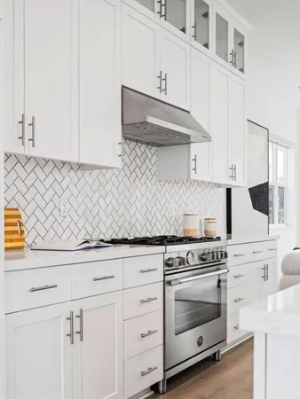 a kitchen with white cabinets and appliances