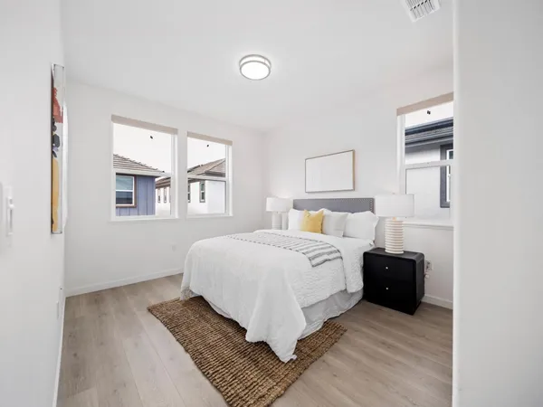 a bedroom with a bed and wooden floor