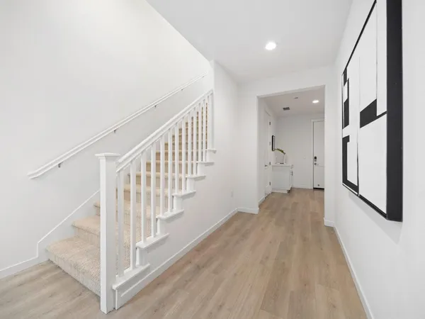 a view of a hallway with wooden floor and entryway
