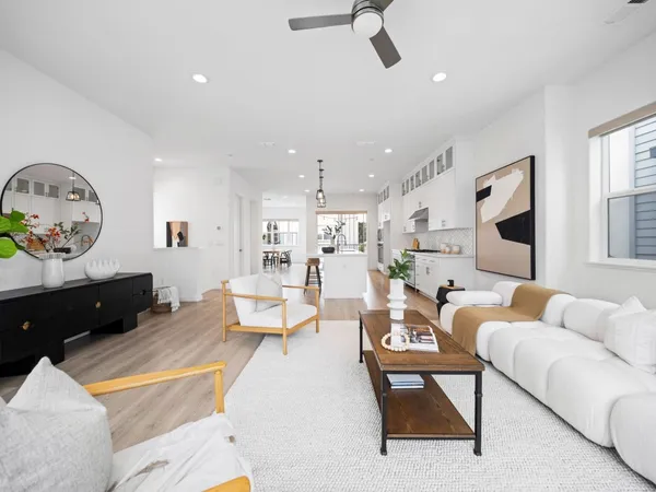 a living room with furniture kitchen view and a window