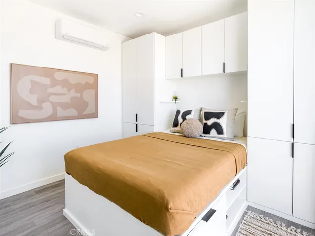 a bedroom with a bed and painting on the wall