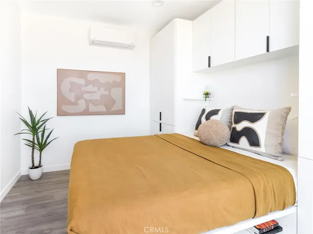 a bedroom with a bed and a potted plant