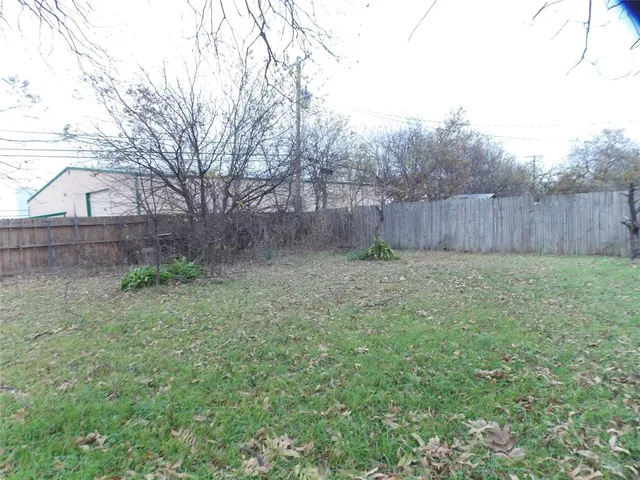 a view of backyard with wooden fence