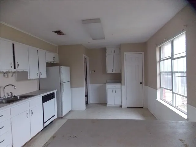 a kitchen with refrigerator and window