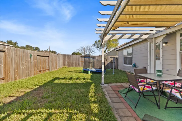 a view of backyard with table and chairs