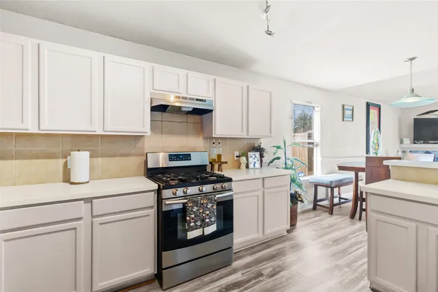 a kitchen with cabinets appliances a sink and a counter top space