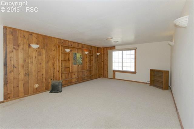 17135 Finch Road Colorado Springs, CO 80928 - Photo 29 of 36 Family room with fun wood wall accents in secondary home!