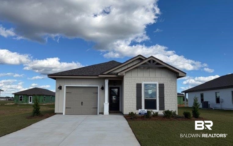 View of front of house with a front lawn, a garage, and driveway