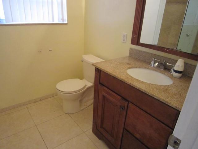 341 Shady Lane Road Palm Springs, FL 33461 - Photo 24 of 24 a bathroom with a granite countertop toilet and a sink