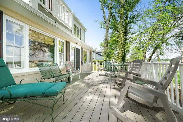 a view of a patio with couches chairs and wooden floor