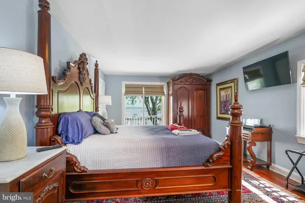 a bedroom with a bed and dresser with mirror