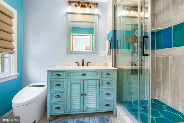 a bathroom with a sink a toilet and shower